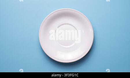 Empty White Coffee Saucer on Blue Background Top View Stock Photo