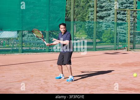 Male tennis player in ready position on clay court during practice Stock Photo