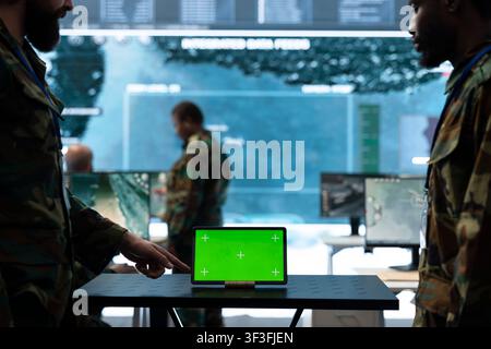 Close up of isolated screen tablet used by army officer gathering intel at workstation. Military headquarters personnel colleagues using chroma key device Stock Photo