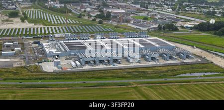 Aerial view of the Google data center facility in Winschoten, featuring large industrial buildings, cooling infrastructure, and adjacent solar panel a Stock Photo