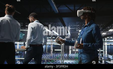 Data center admin wearing VR headset using artificial intelligence neural networks technology. Server hub developer using AI programming language and virtual reality to update hardware, Stock Photo