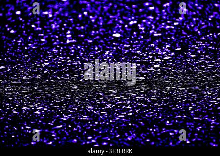 Abstract textured background featuring a sparkling deep purple and black metallic glitter surface. Stock Photo