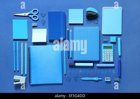 Notebooks and different stationery on blue background Stock Photo