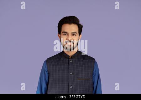 Handsome millennial man of Indian origin smiling on lilac background Stock Photo