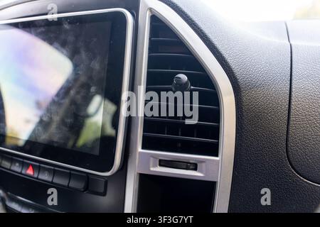 Modern car dashboard featuring touchscreen display, air vent, and control buttons, highlighting automotive technology, driver convenience Stock Photo