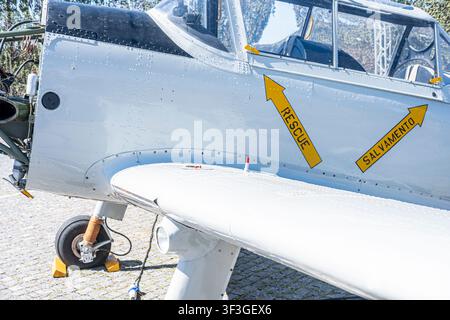Detail of a small aircraft wing and front landing gear parked outdoors on a sunny day Stock Photo