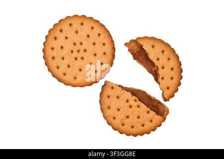 Whole and broken biscuits on a white background. Cookies filled with cocoa. Round cookies. Stock Photo