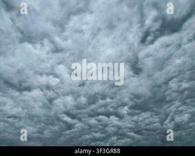 Full frame overcast sky filled with dense layered grey clouds on a cloudy day Stock Photo