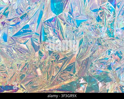 Crumpled iridescent holographic foil surface with prismatic rainbow color shift and crystal facet texture Stock Photo