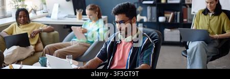 Diverse Coworkers Working on Laptops in Modern Shared Office Stock Photo
