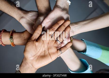 Diverse Team Joining Hands for Workplace Unity and Collaboration Stock Photo