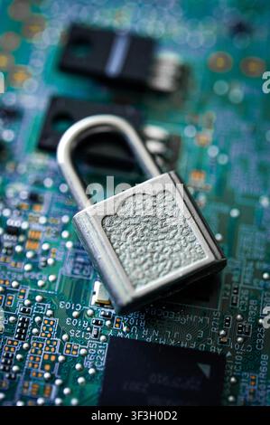 Open silver padlock on a computer circuit board, symbolising cybersecurity, data privacy, digital access and vulnerable technology Stock Photo