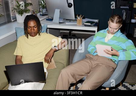 Black Man and Adult Woman Working on Laptop and Tablet in Office Stock Photo