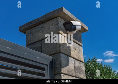 Video surveillance camera installed above the entrance gate to a luxury villa by the sea, security camera, fine for recording video and audio in a pub Stock Photo