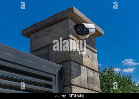 Video surveillance camera installed above the entrance gate to a luxury villa by the sea, security camera, fine for recording video and audio in a pub Stock Photo