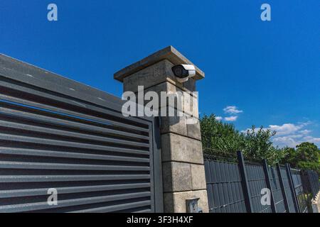Video surveillance camera installed above the entrance gate to a luxury villa by the sea, security camera, fine for recording video and audio in a pub Stock Photo