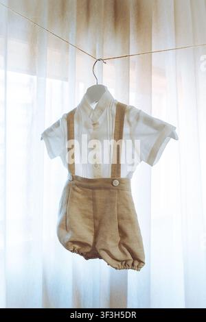 Classic Vintage Linen Baby Boy Baptism Outfit Hanging on Hanger Stock Photo