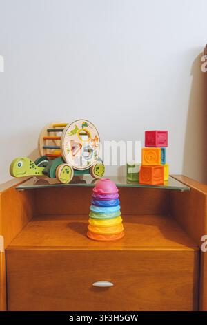 Colorful Baby Development Toys Set on Wooden Bedside Table Stock Photo