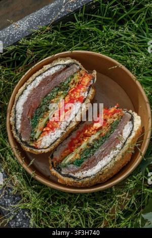 Sushi burger on grass. Delivery box. Isolated. Art photo. Stock Photo