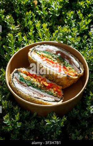 Sushi burger on grass. Delivery box. Isolated. Art photo. Stock Photo