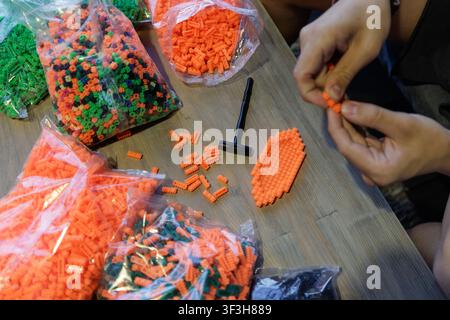 Engaging hands-on activity with colorful plastic construction blocks, promoting fine motor skills and logical thinking for children during educational Stock Photo