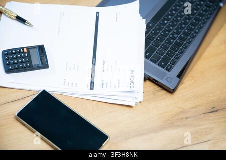 Laptop Stacked Documents And Mobile Phone On Table Stock Photo