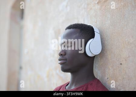 Young Black man with eyes closed enjoying music Stock Photo