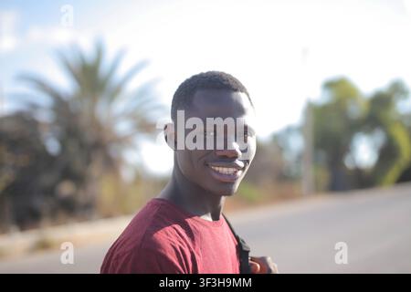 Happy young Black man smiling outdoors in the sun Stock Photo
