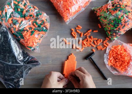 A collection of colorful plastic construction blocks spread on a table, ideal for enhancing fine motor skills and logical thinking in children through Stock Photo