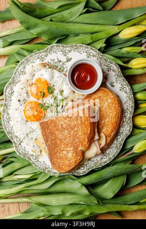English breakfast on a vintage plate against a tulip background, isolated. Professional studio lighting. Top view. Stock Photo