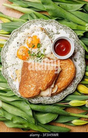 English breakfast on a vintage plate against a tulip background, isolated. Professional studio lighting. Top view. Stock Photo