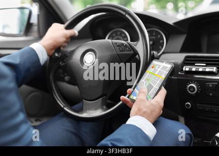 Close up of man using smart phone with gps app in car Stock Photo