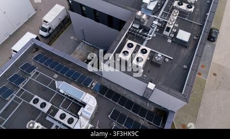 Aerial view of modern data center rooftop with HVAC cooling units and solar panels for cloud computing infrastructure, technology, and green energy. Stock Photo