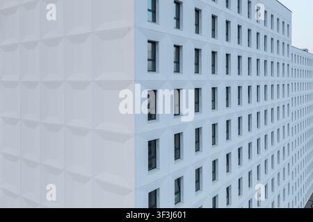 Aerial view of the modern white facade of a building featuring a repeating geometric texture and numerous windows in Krakow, Lesser Poland Voivode, Po Stock Photo
