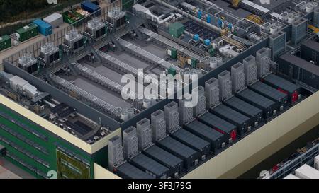 Aerial view of a large-scale data center facility and expansion site in East London. Highlights high density server housing, renewable energy infrastr Stock Photo