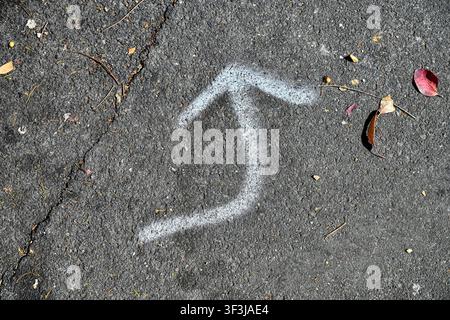 Bent arrow sprayed on path using white paint Stock Photo