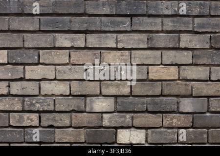 A close-up view of an old brick wall with varied gray and brown tones. The repeating horizontal pattern creates a textured background with no other vi Stock Photo