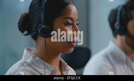 Arabian business woman customer support operator talking with headset in modern call center with multiracial team female helpline agent talk Stock Photo