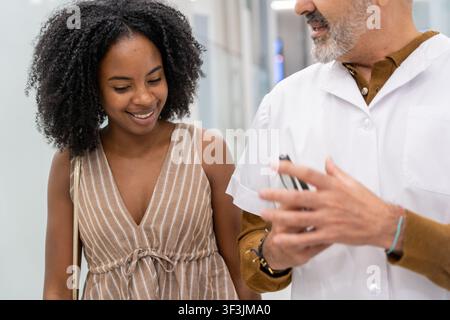 Doctor engaging in conversation with a smiling patient about her health Stock Photo