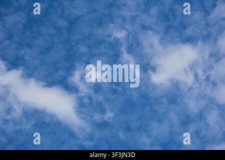 Beautiful bright blue sky filled with soft light white cirrus clouds on clear sunny day Stock Photo