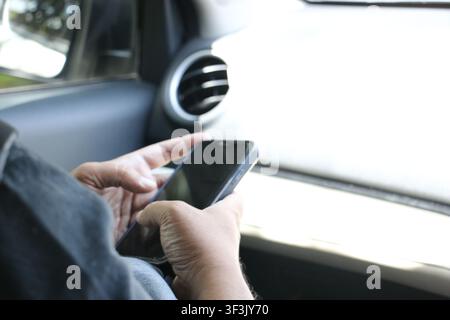 Man Using Smartphone Inside Car, Mobile Phone and Digital Technology for Communication, Navigation and Connectivity Concept Stock Photo