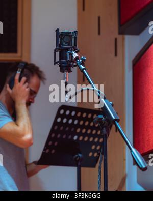 Man behind microphone at recording studio Stock Photo