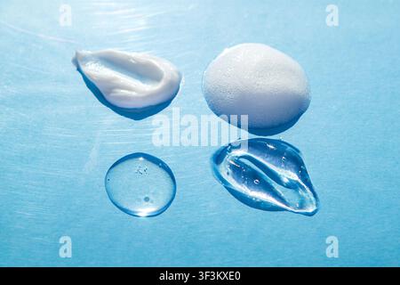 Skincare gel, cream, foam and serum texture samples on blue background, cosmetic product drops Stock Photo