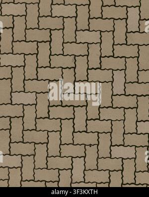 A top-down view of grey concrete pavers in a zigzag or wave pattern, commonly used in parking lots and industrial pedestrian areas. Stock Photo