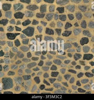 A textured wall surface made of dark blue-grey river stones set in contrasting light beige mortar. Stock Photo
