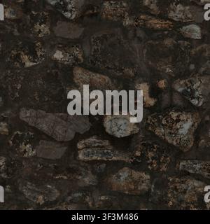 A close-up of a rustic, natural stone wall with irregular dark rocks and thick grey mortar. Stock Photo