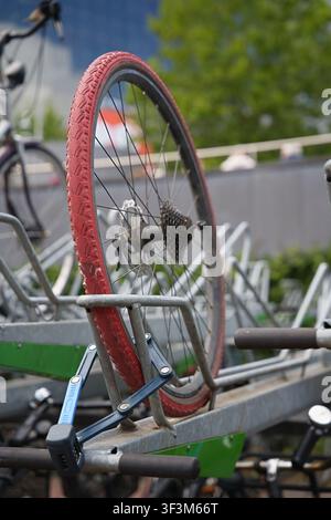The bicycle wheel is locked in the metal stand of the bike rack, but the bicycle itself was stolen. High quality photo Stock Photo
