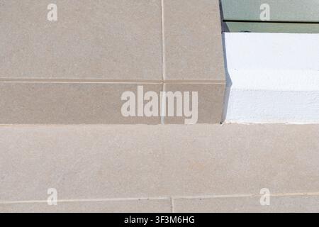 A detailed perspective of outdoor flooring and architectural elements, showcasing contrasting textures and colors in natural light Stock Photo