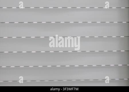 A detailed abstract background showcasing the repetitive pattern of a modern metal security blind with a matte finish and faint highlights Stock Photo