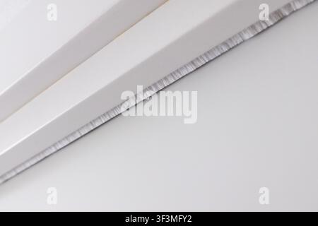 Detailed view of a finely serrated metallic edge, showcasing its precision and texture against a neutral background Stock Photo